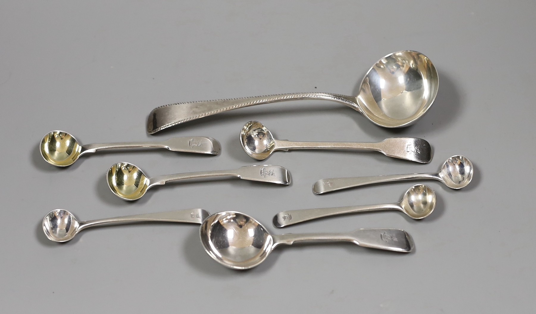 A composite set of six George III Old English pattern and fiddle pattern spoons for condiments, a William IV silver caddy spoons and a Victorian silver sauce ladle, 5.2oz